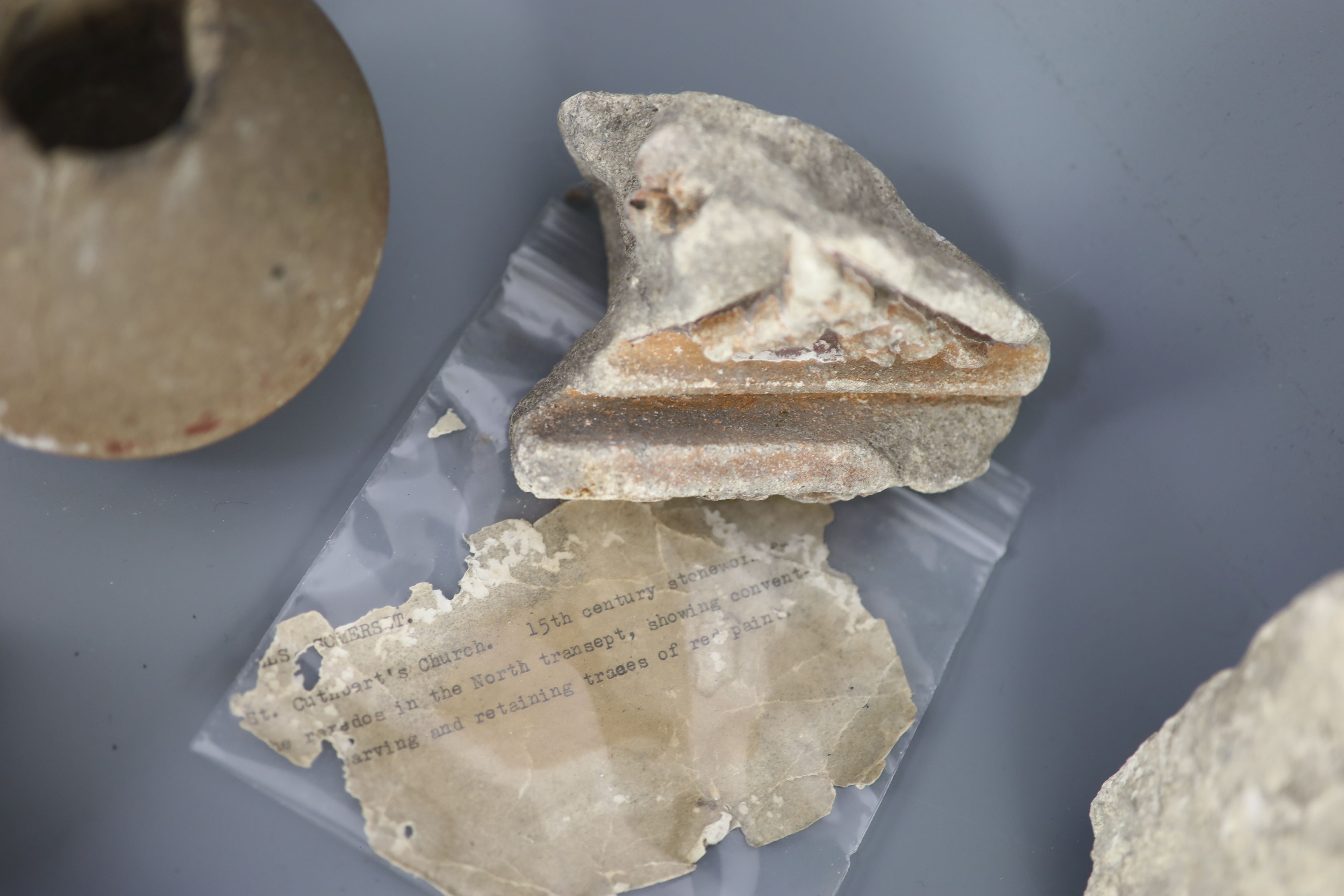 A group of English medieval church/priory architectural stonework and tile fragments, some pieces with inscribed labels of provenance,